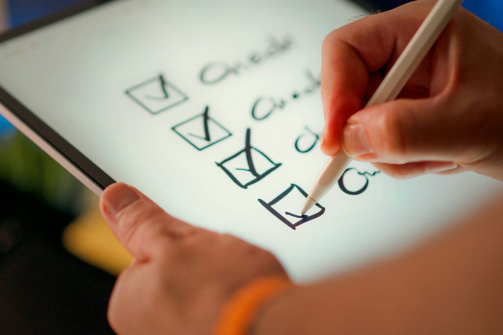 Hand checking off items on a checklist with a stylus
